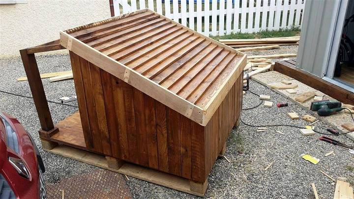 reclaimed pallet dog house with shingled and titled roof